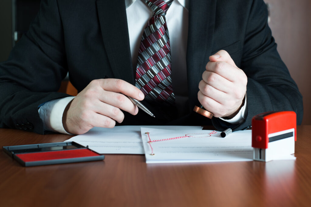 Notary Applying Seal To Documents